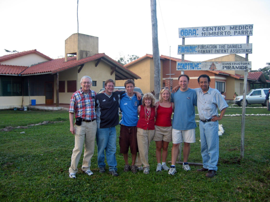 Seven people standing on the lawn in front of the clinic and its original sign